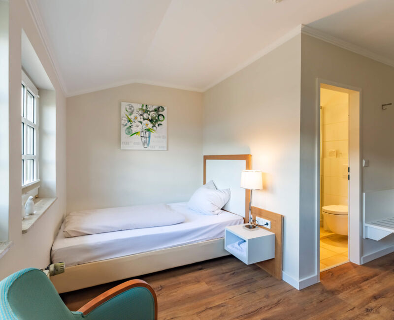 Einzelzimmer auf Gut Altona mit Bett, Schreibtisch und Tageslicht
