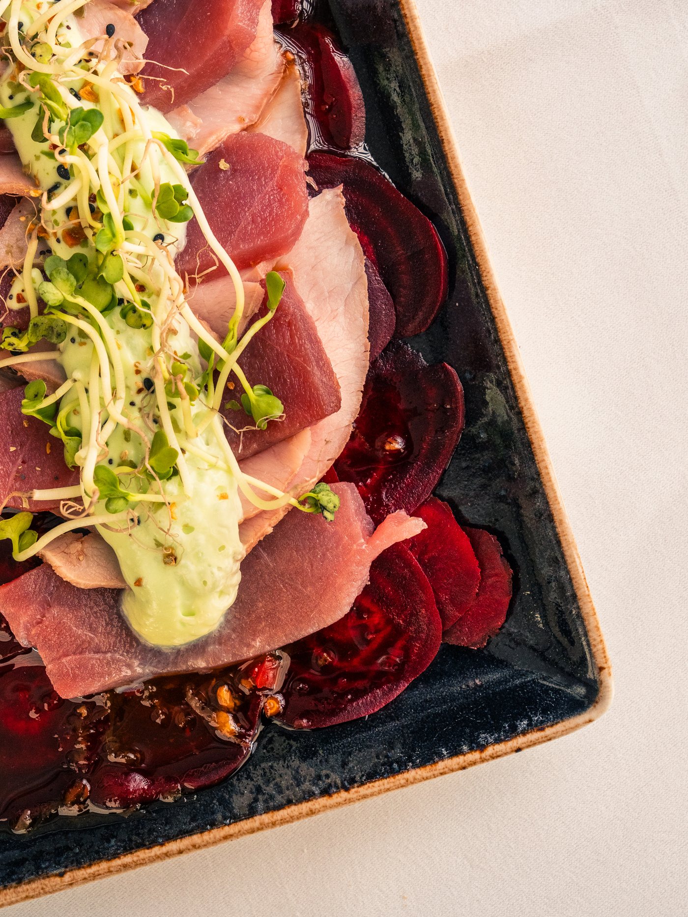 Dünn aufgeschnittenes Fleisch auf mariniertem Rote Bete mit Kräutern – Vorspeise im Restaurant Gut Altona