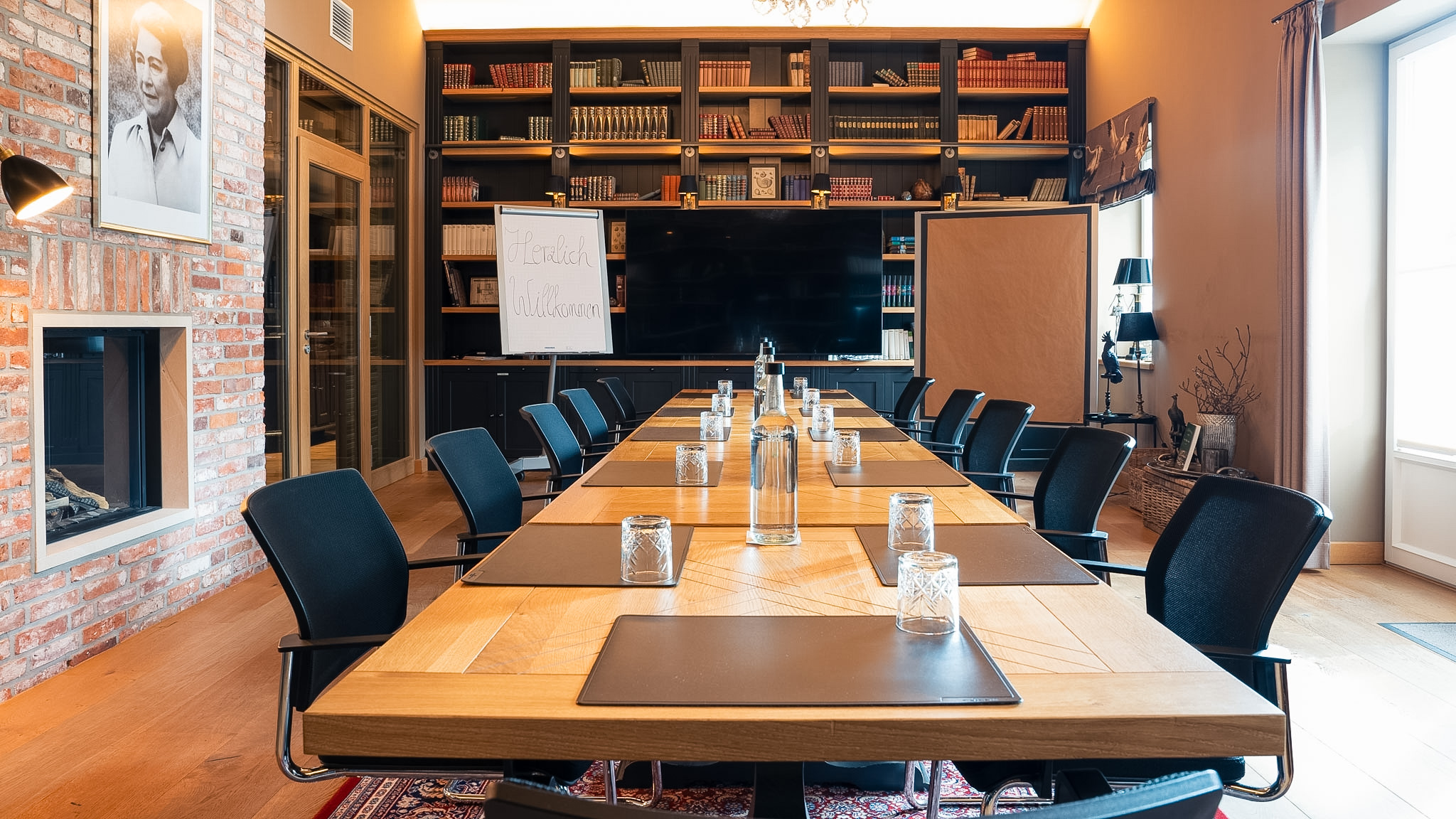 Tagungsraum Bibliothek auf Gut Altona – Konferenztisch vor Bücherwand und Kamin