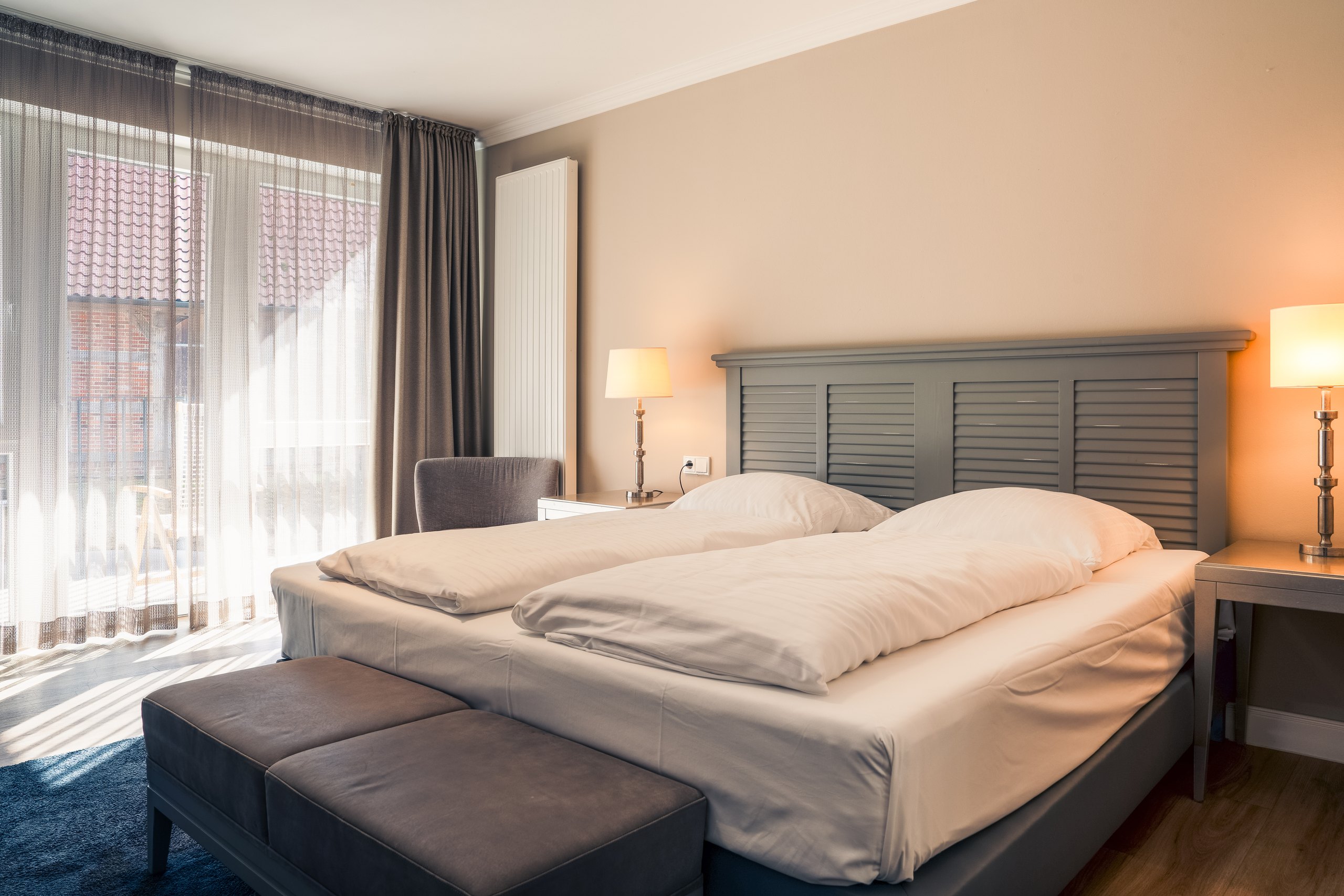 Business-Doppelzimmer auf Gut Altona mit Doppelbett vor bodentiefen Fenstern