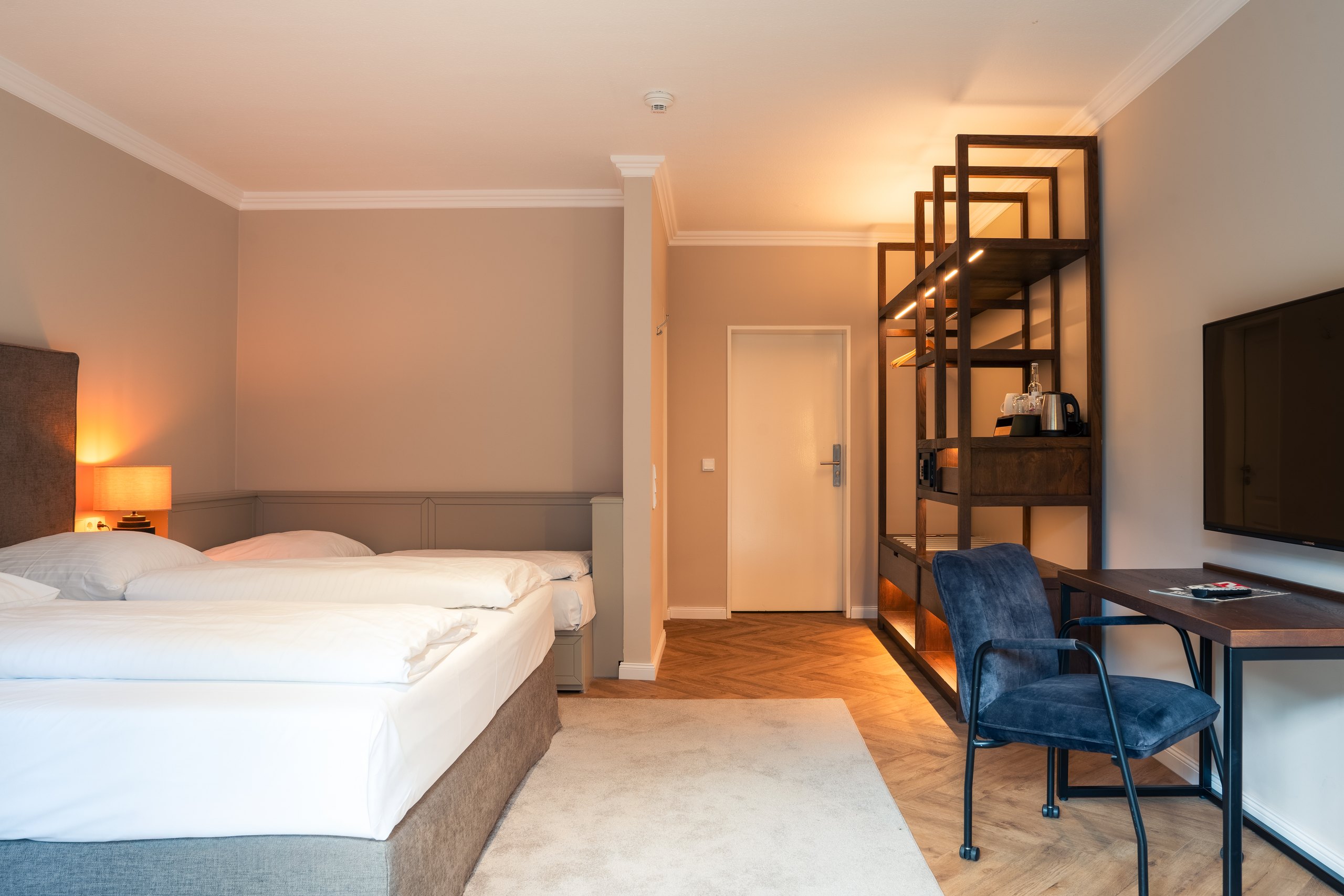 Business-Dreibettzimmer auf Gut Altona mit Doppelbett, Einzelbett, Regal und Arbeitsplatz