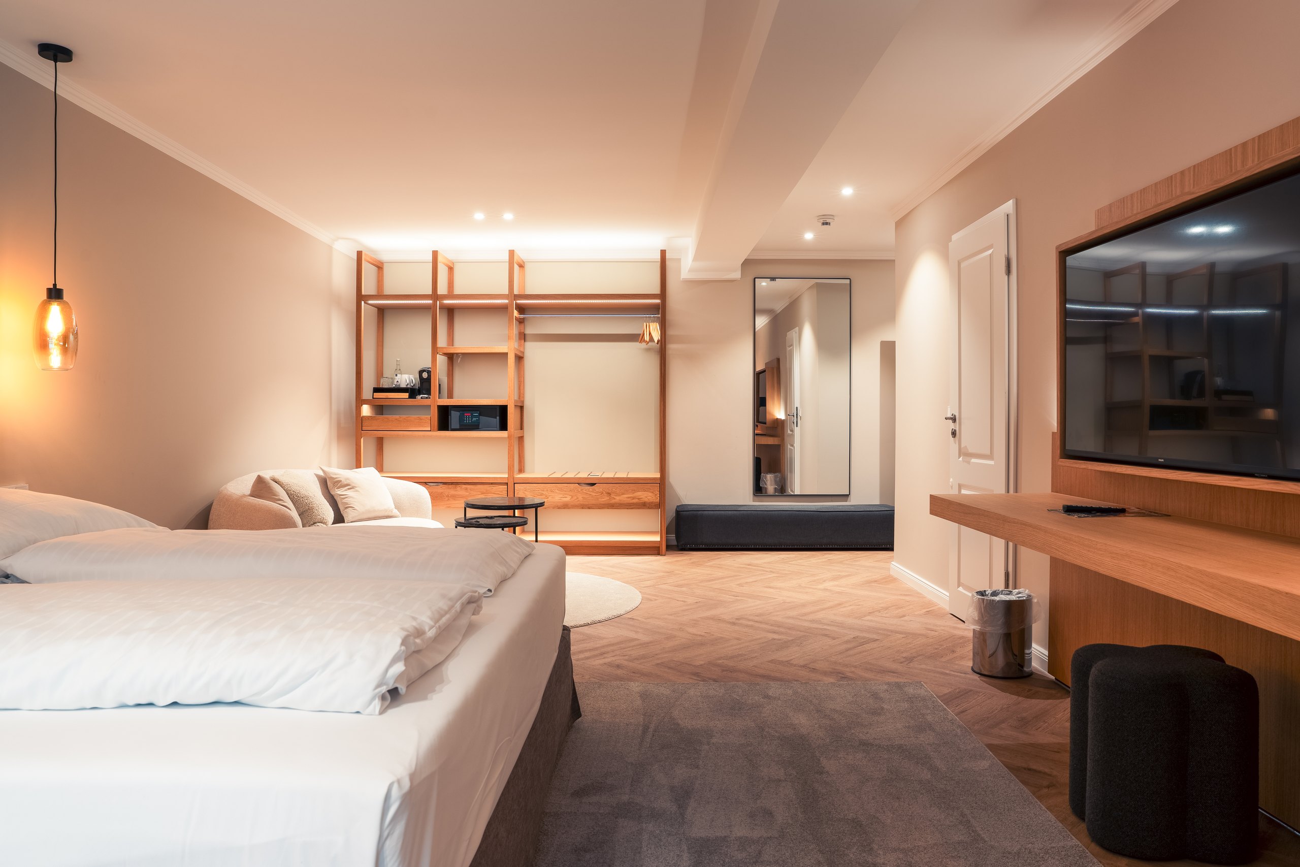 Premium-Doppelzimmer auf Gut Altona mit offenem Regal, Fernseher und Fischgrätparkett