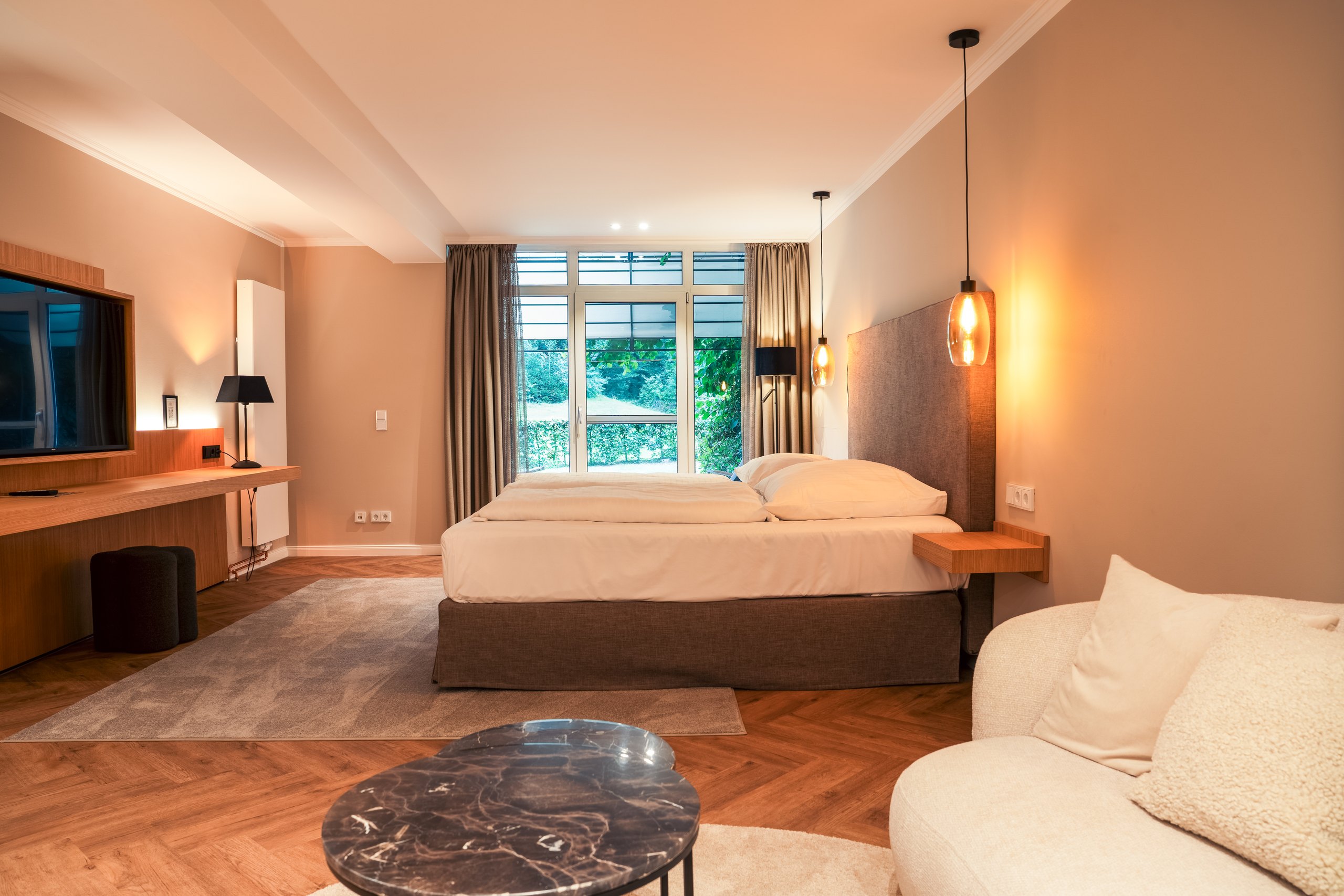 Premium-Doppelzimmer auf Gut Altona mit Sitzbereich, Sofa und Blick ins Grüne