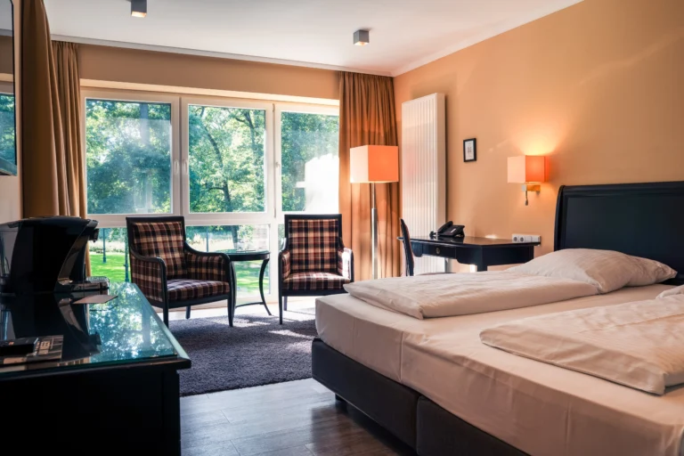Premium-Doppelzimmer auf Gut Altona mit Sitzecke am Fenster und Blick in den Park